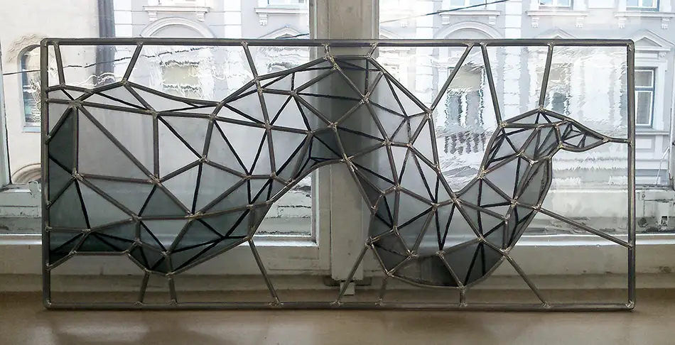 Detail of monochrome lead glazing with geometric pattern in old building entrance doors and fanlights