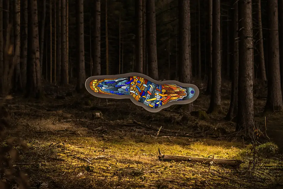 front view of a free-hanging and illuminated stained glass window with detailed painting which is named Amoeba and hangs in a forest