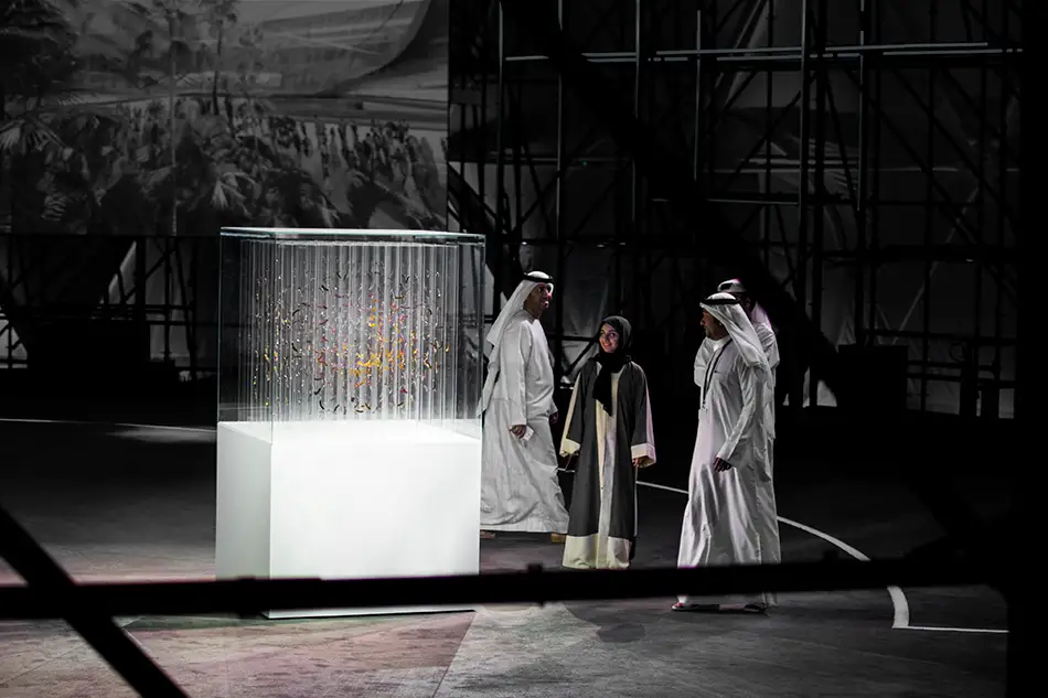Exhibition view with people from anamorphic glass sculpture by Thomas Medicus for EXPO2020 in Dubai