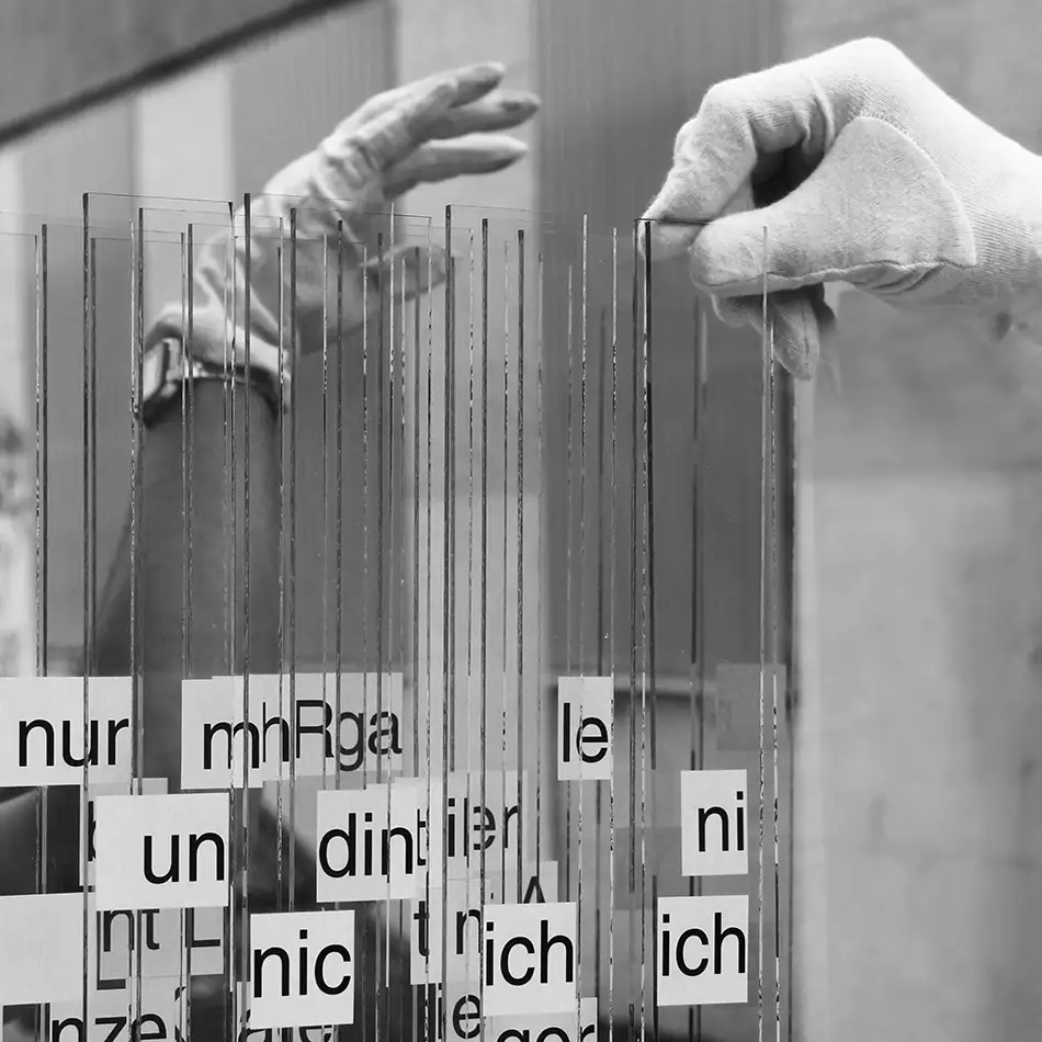 Anamorphe Glas-Kunst-Installation namens 404 Ort mit Text von Martin Fritz während Aufbau mit Händen
