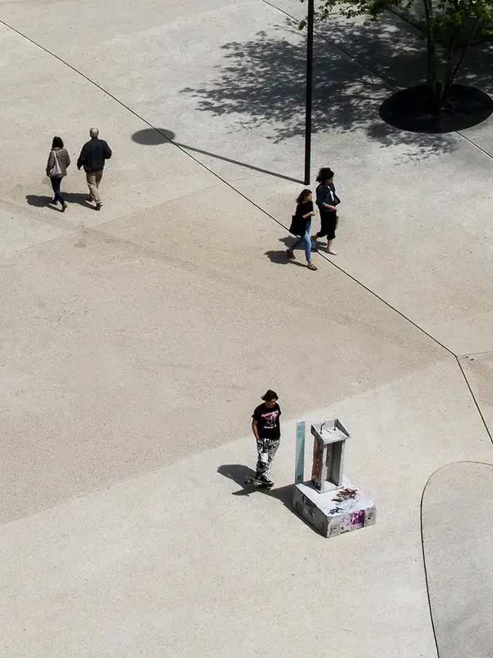 Dilapidated concrete lectern as art in public space with people at Landhausplatz Innsbruck