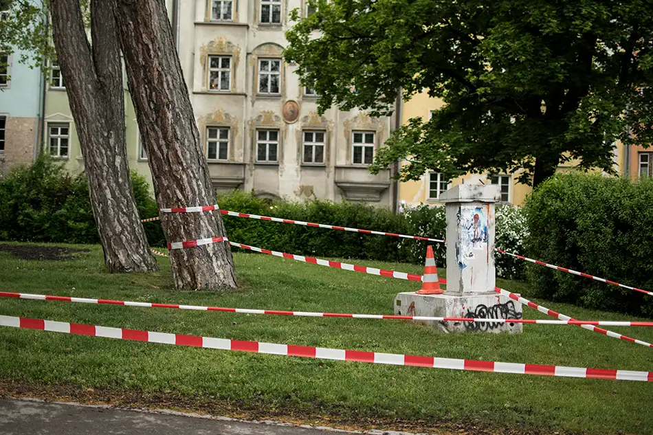 Dilapidated concrete lectern as art in public space at Waltherpark Innsbruck with barrier tape