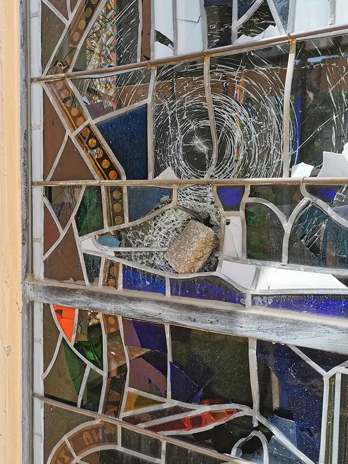 new-production of stained glass windows for the Dominikanerkirche Eppan - paving stone is stuck in the window before the restoration